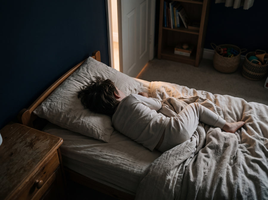Kind liegt wach im dunklen Zimmer und schaut zur Decke